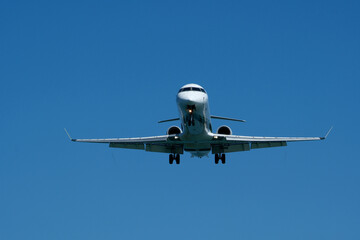 Airplane Landing Approach Against Clear Blue Sky. Airplane in the blue sky, close-up of the plane