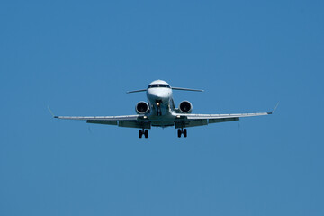 Airplane Landing Approach Against Clear Blue Sky. Airplane in the blue sky, close-up of the plane