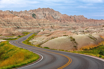 A winding road through colorful mountains and hills in Badlands National Park, South Dakota, USA....