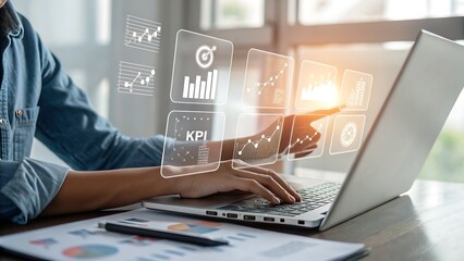 Photo of a person uses a laptop to analyze business data displayed as interactive charts and graphs