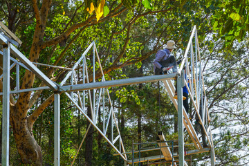 Welding Metal Frame in Nature, Workers Assembling Steel Structure Among Forest Trees