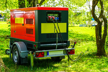 Portable Power Generator Operating Outdoors in a Sunny Forest Setting with Cables Attached