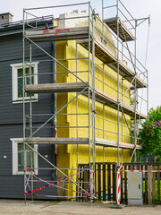 Scaffolding and Thermal Insulation Installation on a Residential House Exterior Wall