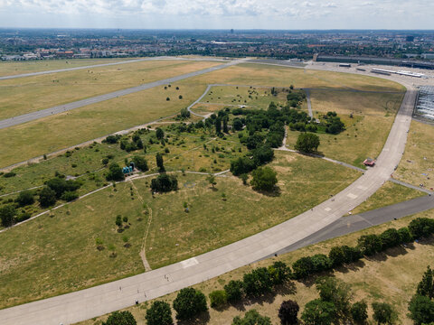 Aerial view of Tempelhofer Feld's vast expanse with the runways cutting through the greenery, creating a stark contrast between nature and concrete, Berlin, Berlin, Germany.