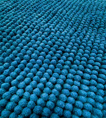 Hand-knotted blue wool loop rug with textured pom-pom pattern, ideal for cozy home interiors,...
