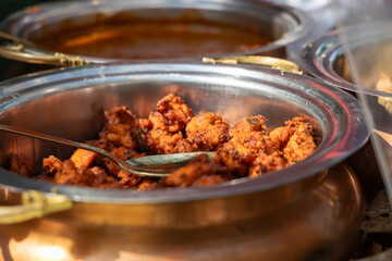 Close-up of spicy chicken in a serving dish with spoon