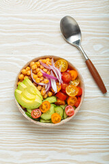 Healthy chickpea salad with ripe avocado, juicy cherry tomatoes, crisp cucumber, and red onion slices. Perfect for a nutritious and healthy meal
