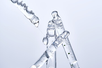 Four different face serum pipettes on a neutral background.