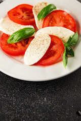 Caprese salad mozzarella and tomato, basil fresh delicious gourmet food background on the table rustic food top view copy space keto and paleo diet vegan and vegan food