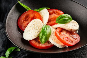 Caprese salad mozzarella and tomato, basil fresh delicious gourmet food background on the table rustic food top view copy space keto and paleo diet vegan and vegan food