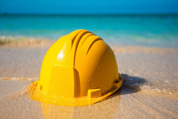 Yellow hard hat submerged in gentle ocean waves on a sandy beach