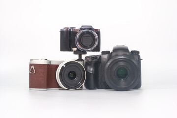 Various cameras arranged creatively on a white background showcasing different styles and sizes in photography equipment