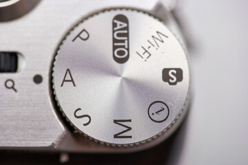 Camera settings dial showing various modes including manual, auto, and Wi Fi settings in a close up...
