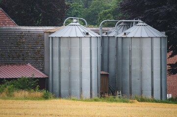 Silos storing harvested crops on agricultural farm in rural landscape