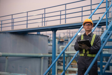 Petrochemical engineer working at petroleum oil refinery industry area. Industrial technician worker maintenance inspect manufacturing energy power gas system at factory.