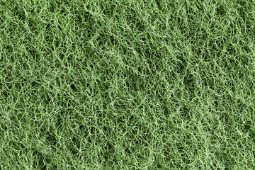 Green tangled fiber texture close-up. Chaotic intertwined lines pattern in macro view. Abstract web of synthetic filaments. Messy structure of thin thread loops. Detailed network of wiry strands.