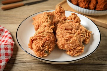 Fried chicken in a white plate on wooden background
