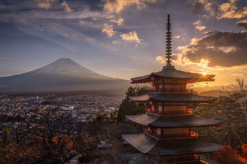 View of the Chureito Pagoda with Mount Fuji under a golden sunset sky, its silhouette contrasting with the vibrant colors, Fuji, Shizuoka, Japan.