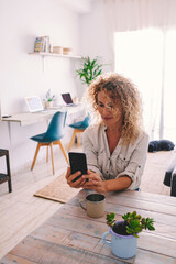 Mature woman using her smartphone at home in various situations. From socializing and working to...