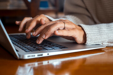 Curly-haired woman in her 40s using a laptop at home with varied expressions. Remote work, digital...