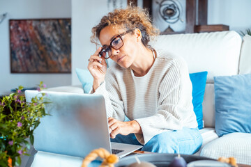 Curly-haired woman in her 40s using a laptop at home with varied expressions. Remote work, digital life, emotions and everyday routines of a modern woman navigating technology and real-world challenge