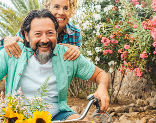 Happy couple riding bicycles outdoors, having fun and being silly together. Love, joy, freedom, playful moments, healthy lifestyle and enjoying life as an active and carefree couple in nature