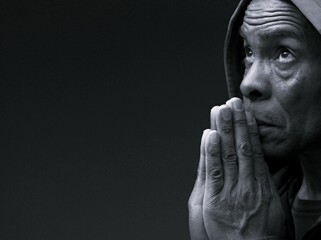 man praying to god with hands together Caribbean man praying with black background with people stock photo stock image