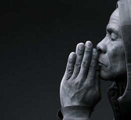 man praying to god with hands together Caribbean man praying with black background with people stock photo stock image