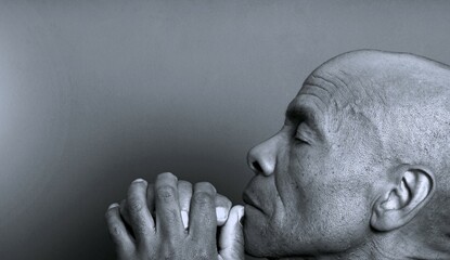 man praying to god with hands together Caribbean man praying with black background with people stock photo stock image