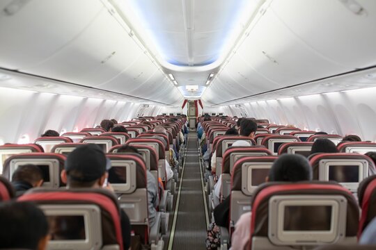 Clean and orderly view of an airplanes economy class cabin.