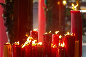Group of tall red candles burns brightly.