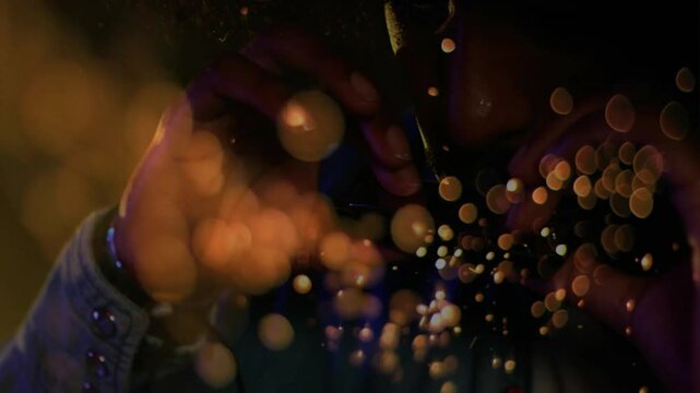 Man striking lighter in VFX studio for smoking, creating sparks drifting around hands and mouth