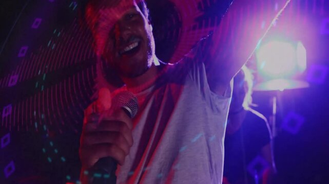Male singer adjusting mic and singing in music, purple lights rippling across keyboard