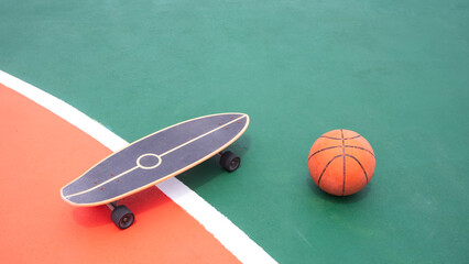 Skateboard and basketball on colorful outdoor basketball court, High angle view with copy space