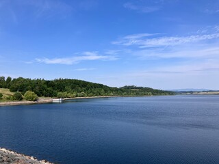 Sunny View of the Slezská Harta Reservoir in the Czech Republic – Mountain Landscape and Blue Sky in the Background