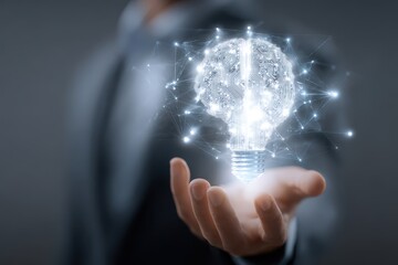 Innovative business concept showcasing the fusion of technology and creativity through a light bulb designed as a brain held in a businessman's hand during a brainstorming session