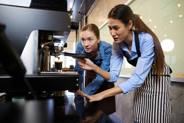 female baristas making fresh coffee from machine in the cafe