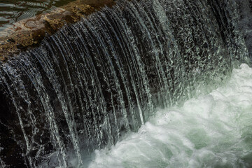 water flowing over concrete structure at sunny day