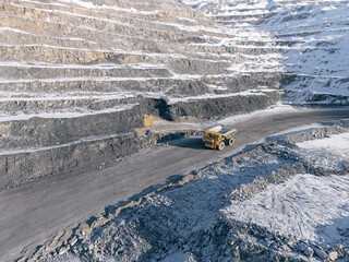 Winter scene of open pit coal mine with mining big truck