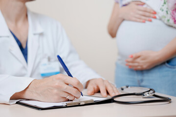 Doctor and woman patient discuss about abdominoplasty plastic surgery of belly after pregnancy in...