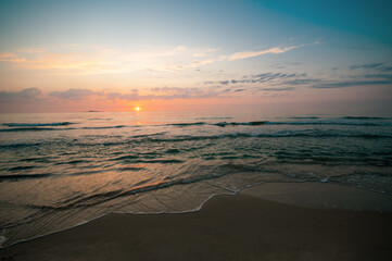 Beautiful colorful sunset in cloud sky at tranquil sea