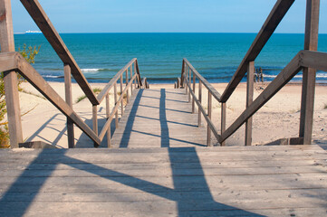 Wooden stairs leading to the empty sand beach