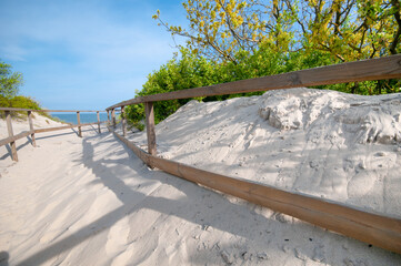 Wooden stair at dunes leading  to the sand beach