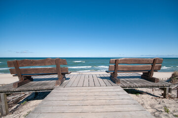 Empty wooden benches at a sea coast line