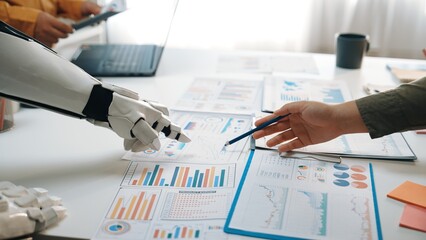 A human and robot collaborate in a modern office environment, engaging in data analysis with...