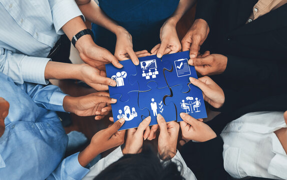 This image captures the essence of collaboration and management as hands come together to connect puzzle pieces, symbolizing teamwork and strategic business development. Amity