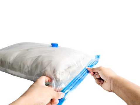 Person sealing a vacuum storage bag filled with clothes and bedding isolated on transparent background