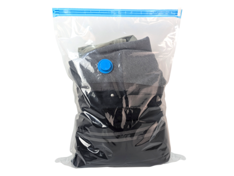 Clothes packed tightly in a clear vacuum seal storage bag with a blue valve isolated on transparent background