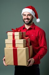 Smiling man holding christmas gifts wearing santa hat and red shirt