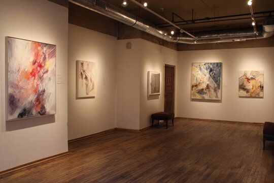 Exploring contemporary art in a minimalistic gallery setting during a vibrant exhibition of local artists' works